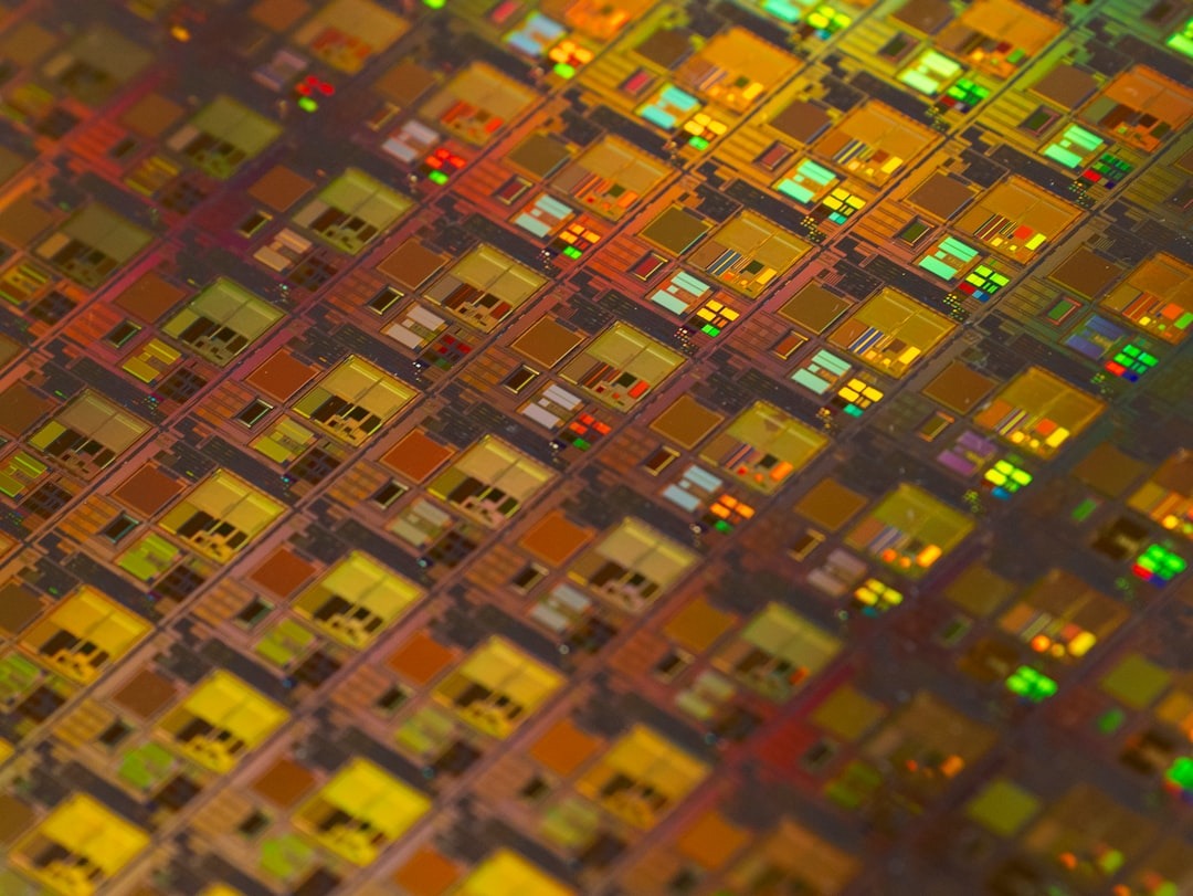 Colorful semiconductor wafer with intricate microchip patterns.